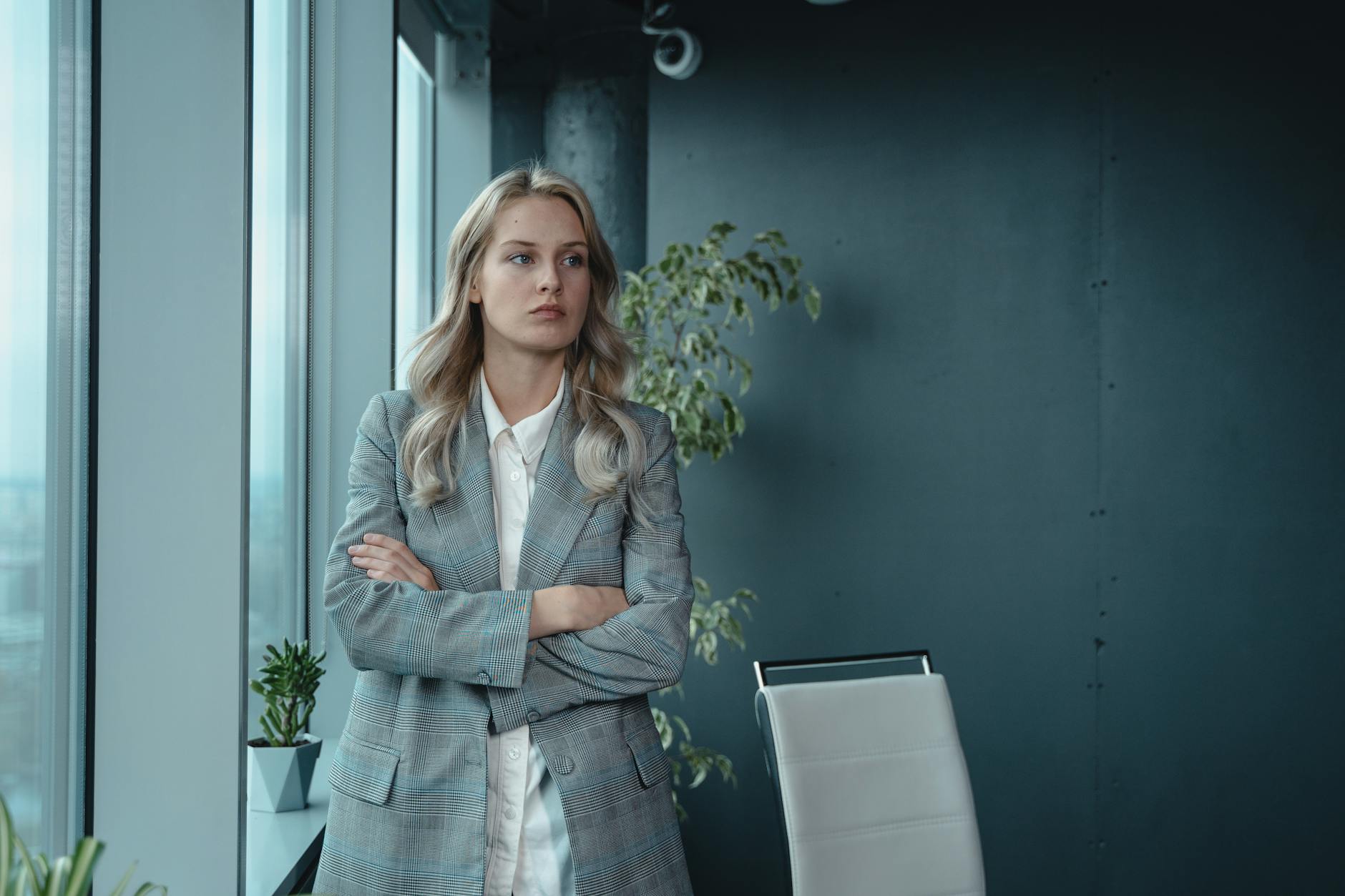 A professional businesswoman stands confidently in a modern office, exuding leadership and determination.