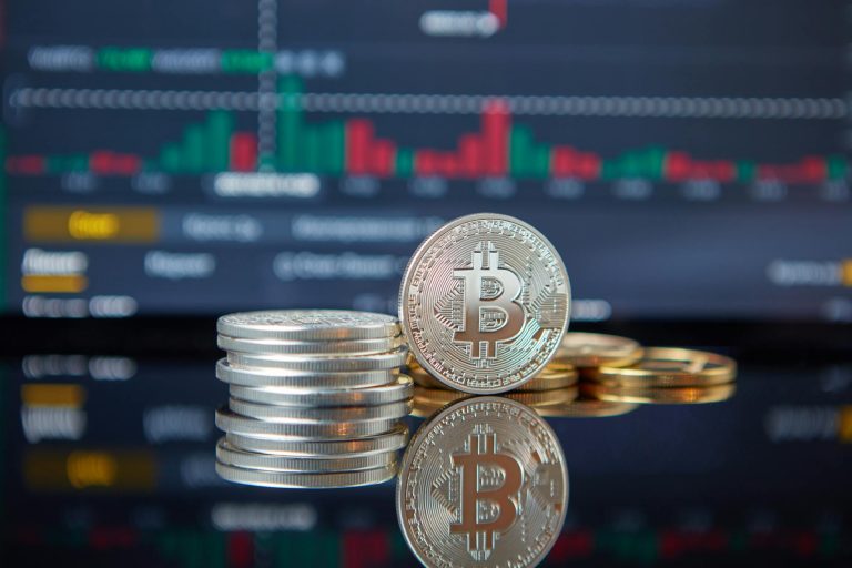 Stack of Bitcoin coins in front of a stock market graph, reflecting cryptocurrency trends.
