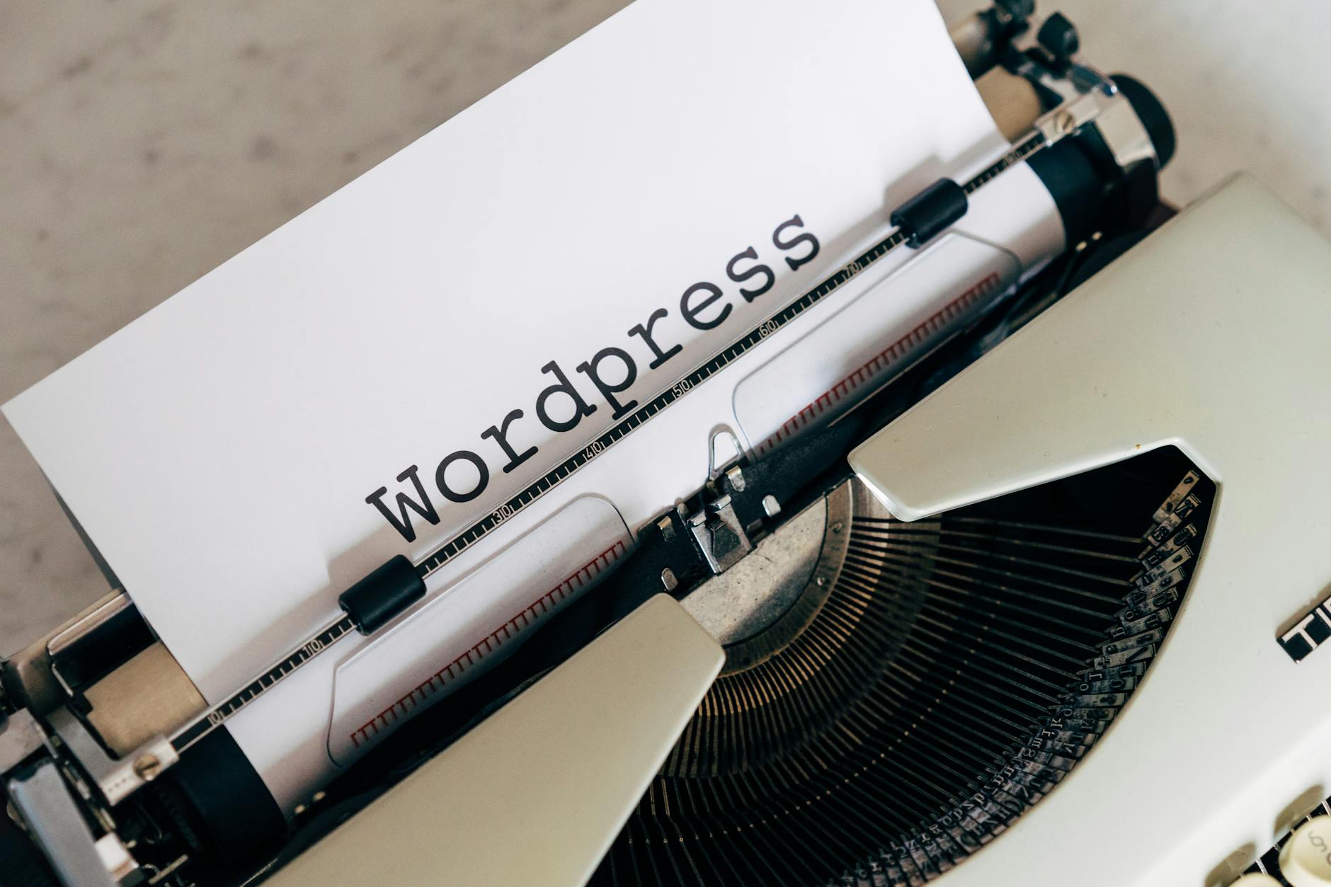 Close-up of a vintage typewriter with a paper displaying 'WordPress', ideal for blogging and writing concepts.