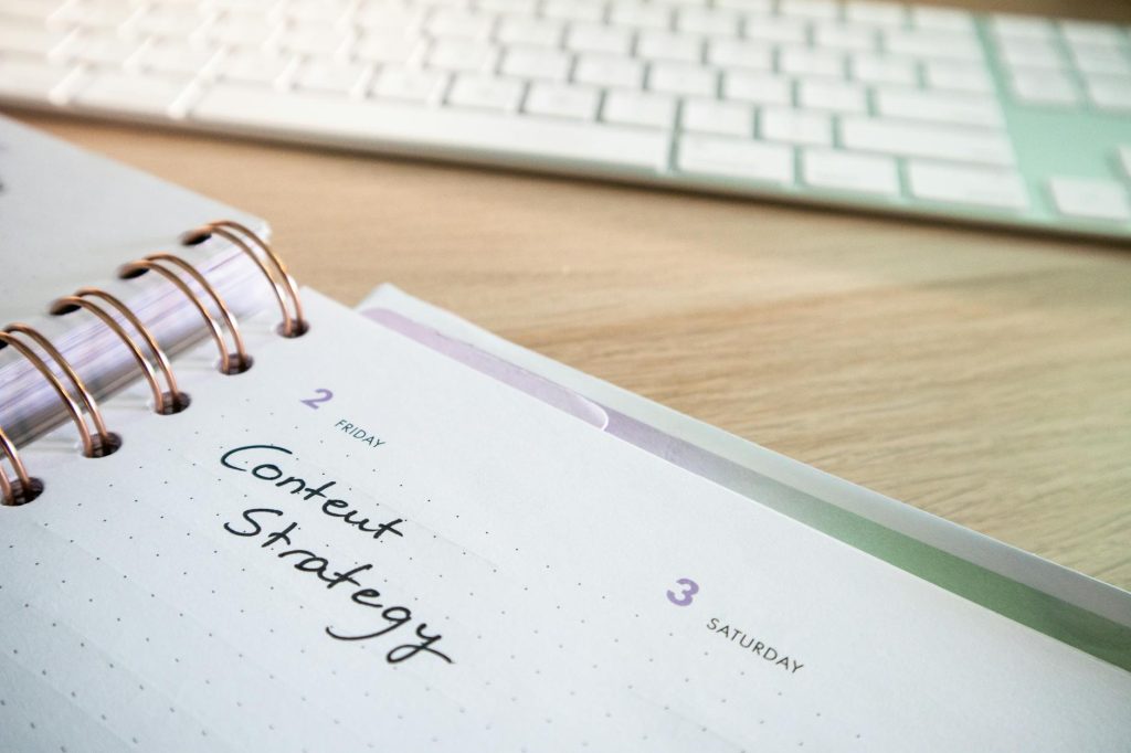 Content strategy written in planner with keyboard on wooden desk