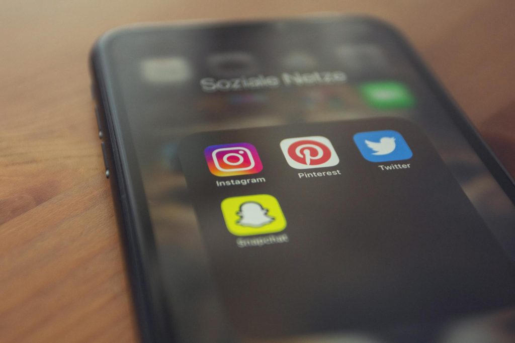 Smartphone displaying popular social media apps like Instagram, Pinterest, Twitter, and Snapchat.